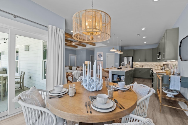 dining room featuring ceiling fan with notable chandelier, light wood-type flooring, and recessed lighting