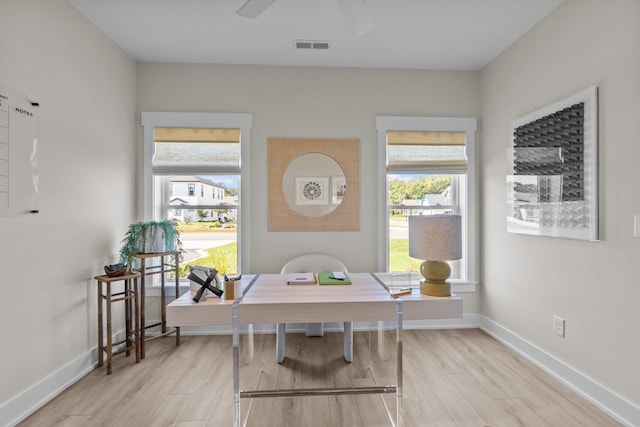 home office with light wood-style floors, plenty of natural light, and ceiling fan