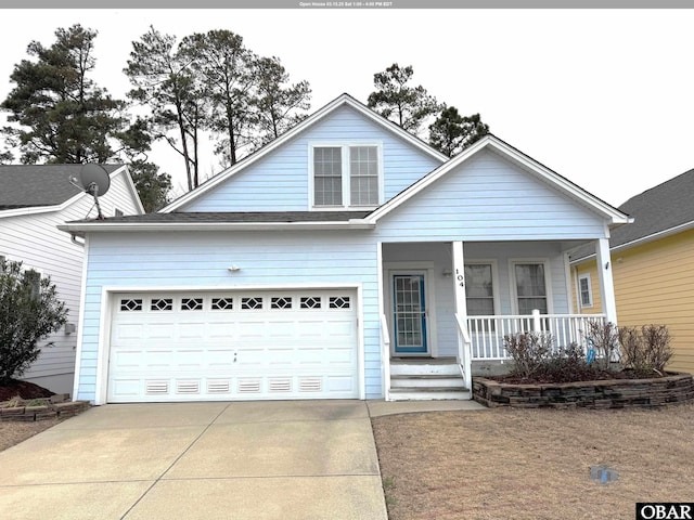 view of front of home featuring concrete driveway, a porch, and a garage