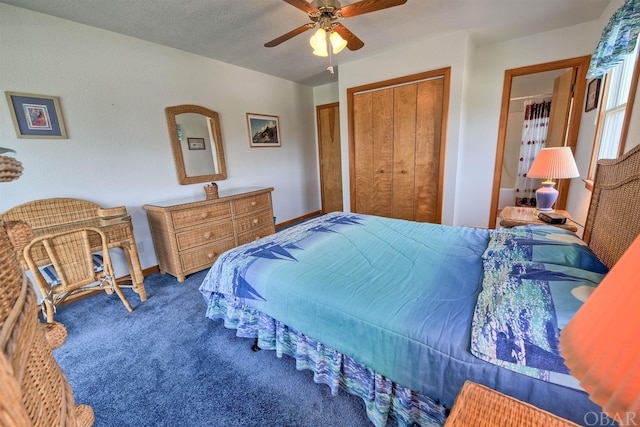 bedroom featuring baseboards, ceiling fan, dark carpet, and a closet
