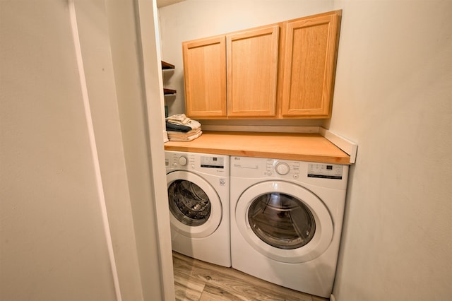 washroom with washer and clothes dryer, cabinet space, and light wood-style floors