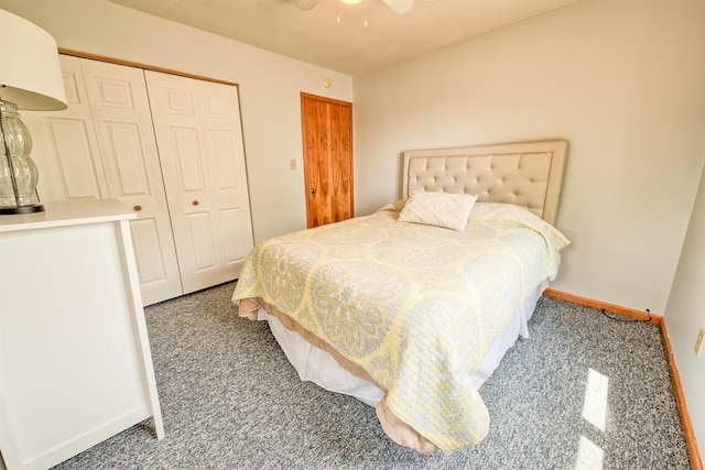 bedroom with a ceiling fan, baseboards, dark colored carpet, and a closet