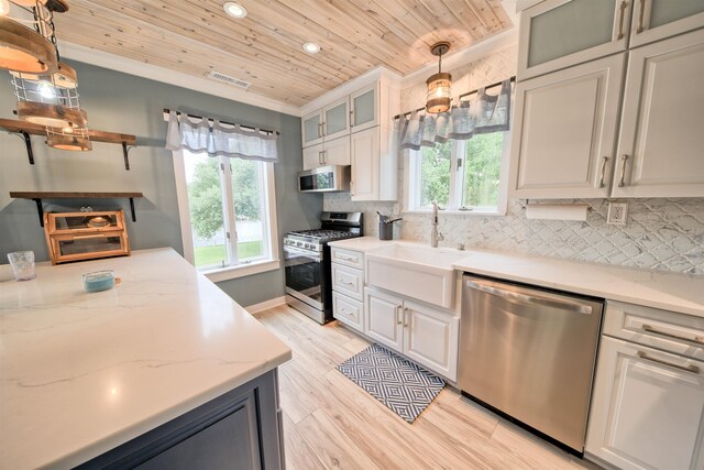 kitchen with stainless steel appliances, decorative light fixtures, glass insert cabinets, and visible vents