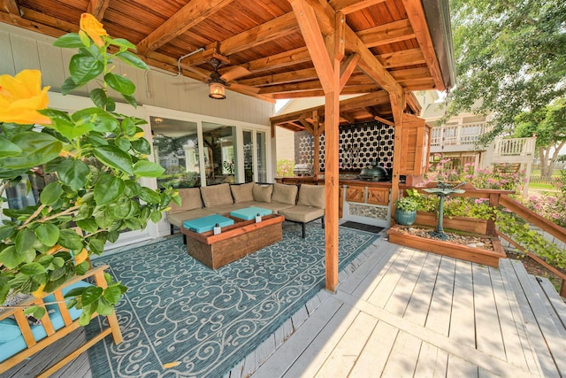 wooden terrace featuring grilling area and an outdoor living space