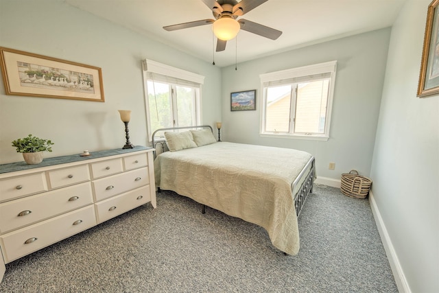 bedroom featuring dark colored carpet, multiple windows, ceiling fan, and baseboards