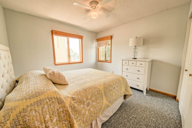 bedroom featuring a textured ceiling, dark colored carpet, a ceiling fan, and baseboards