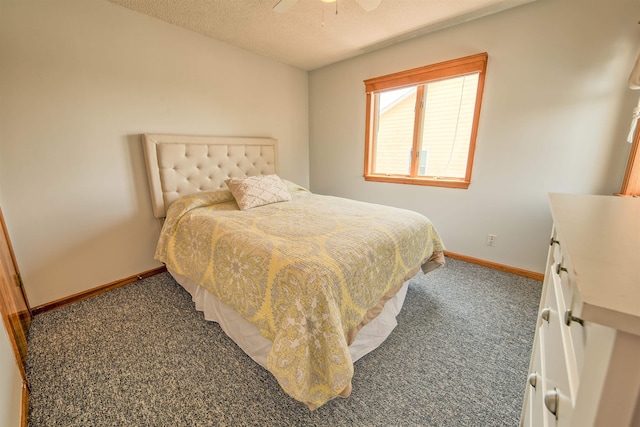 bedroom with dark colored carpet, ceiling fan, a textured ceiling, and baseboards