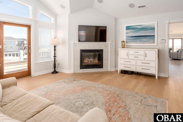 1918 Sandfiddler Rd Lot A, Lot A, Corolla, NC 27927 - living area featuring vaulted ceiling, light wood finished floors, a glass covered fireplace, and baseboards