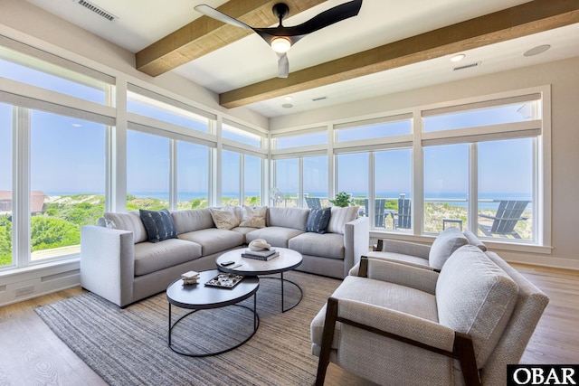 sunroom featuring beamed ceiling, a water view, visible vents, and a ceiling fan