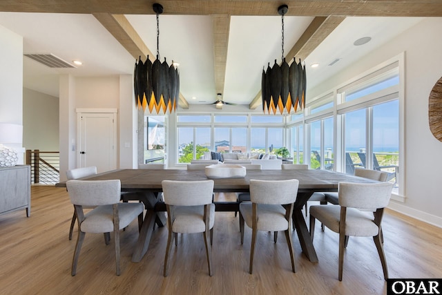 dining room featuring plenty of natural light, visible vents, and beamed ceiling