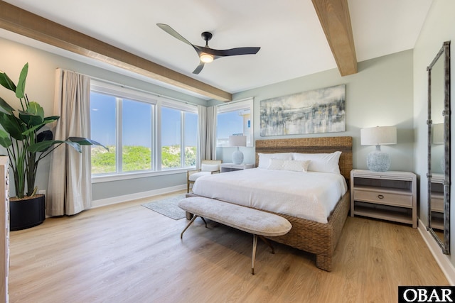 bedroom featuring light wood finished floors, a ceiling fan, baseboards, and beam ceiling