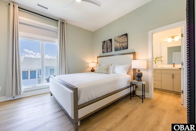 bedroom with ensuite bathroom, ceiling fan, visible vents, baseboards, and light wood-style floors