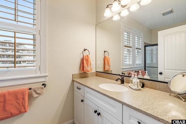 bathroom with visible vents, a stall shower, and vanity