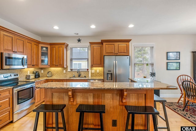 kitchen featuring a kitchen bar, appliances with stainless steel finishes, and a center island