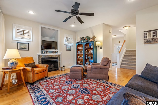 living room with recessed lighting, stairway, a premium fireplace, light wood-style floors, and ceiling fan