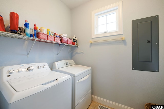 washroom with light tile patterned flooring, washing machine and dryer, laundry area, baseboards, and electric panel