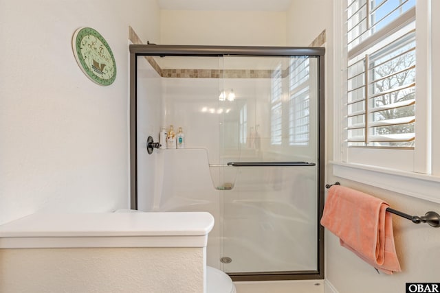 full bath featuring toilet and a stall shower