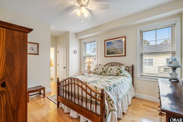 bedroom featuring light wood-style flooring, baseboards, a ceiling fan, and ensuite bathroom