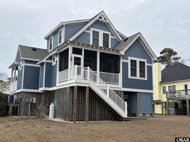 rear view of property with a shingled roof, central AC unit, a sunroom, stairs, and board and batten siding