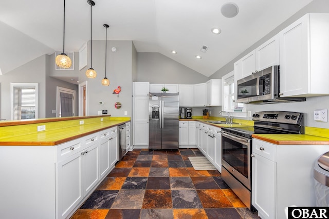 kitchen featuring stainless steel appliances, a sink, visible vents, white cabinets, and hanging light fixtures