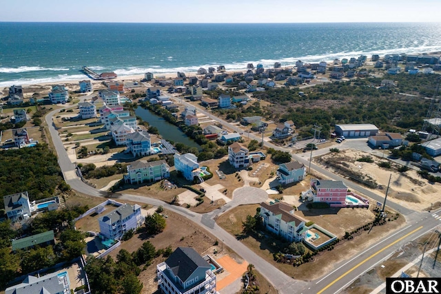 drone / aerial view featuring a beach view and a water view