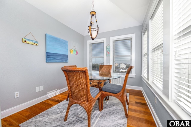 dining area with vaulted ceiling, dark wood-style flooring, and baseboards