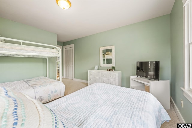 bedroom with carpet floors, baseboards, and a closet