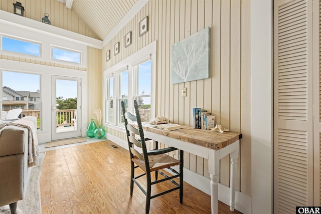 sunroom with vaulted ceiling, wood finished floors, and visible vents