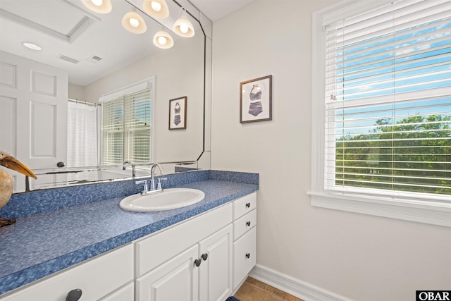full bath with baseboards, vanity, and tile patterned floors