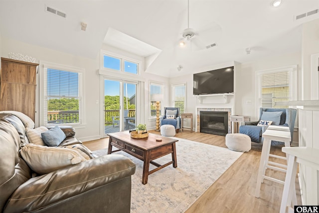 living room featuring light wood-style floors, plenty of natural light, a glass covered fireplace, recessed lighting, and a ceiling fan