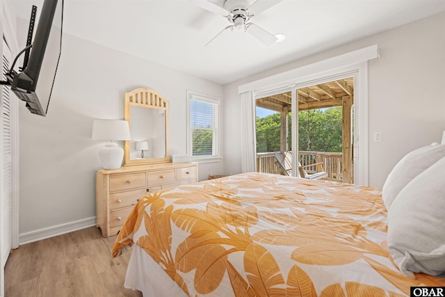 bedroom featuring access to outside, multiple windows, light wood finished floors, and baseboards