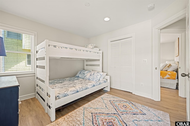 bedroom featuring baseboards, wood finished floors, and a closet