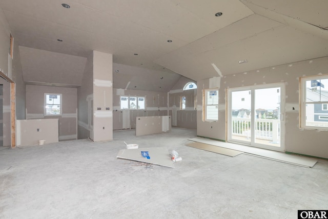 spare room featuring lofted ceiling and plenty of natural light