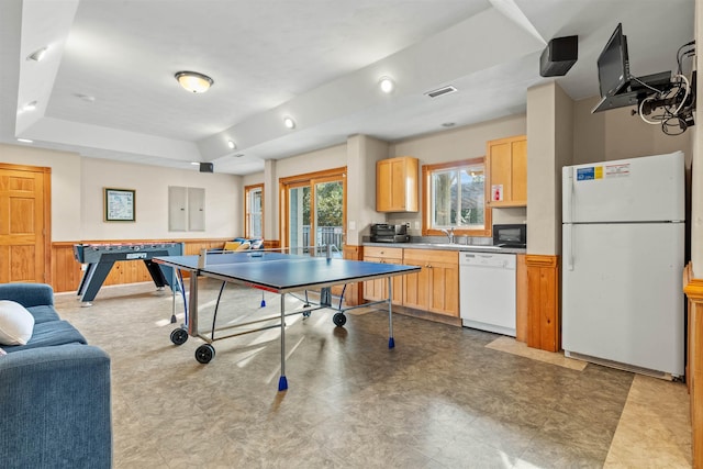 game room with a raised ceiling, visible vents, and wainscoting