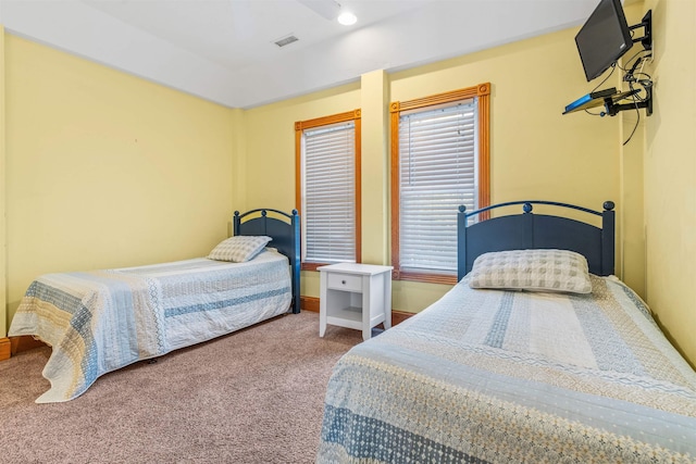 carpeted bedroom featuring baseboards and visible vents