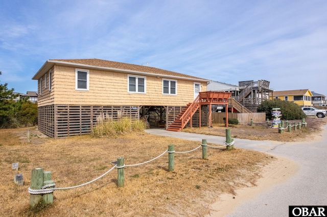 view of front facade featuring driveway, stairway, and a carport