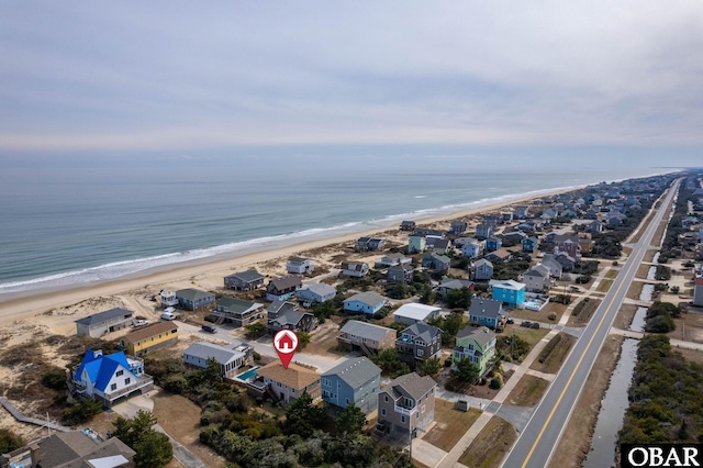 birds eye view of property with a water view and a view of the beach