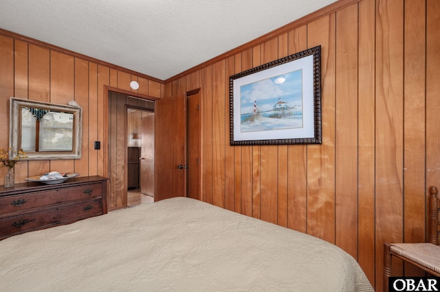 bedroom featuring wood walls, ornamental molding, and a textured ceiling