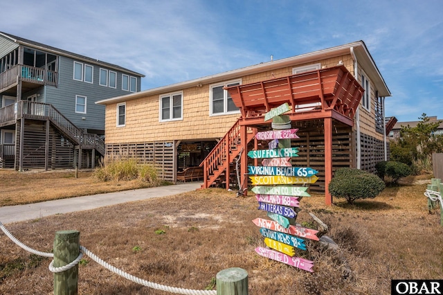 exterior space with concrete driveway, a carport, and stairway