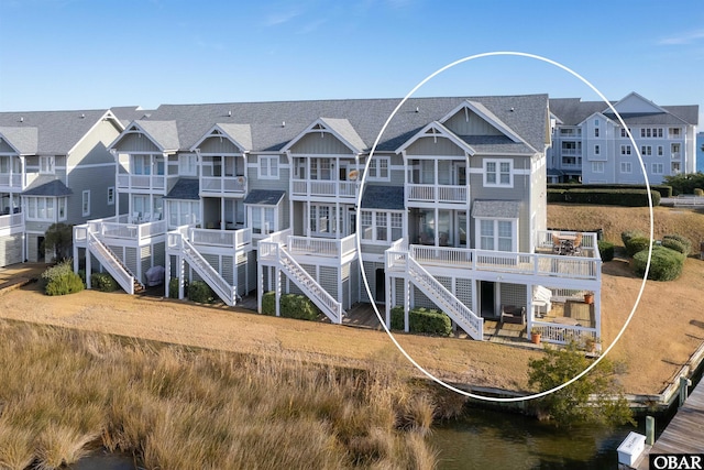 rear view of property with a water view and a residential view