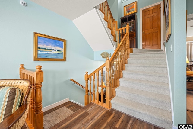 stairway featuring baseboards and wood finished floors