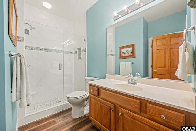 full bath with toilet, a stall shower, wood finished floors, and vanity