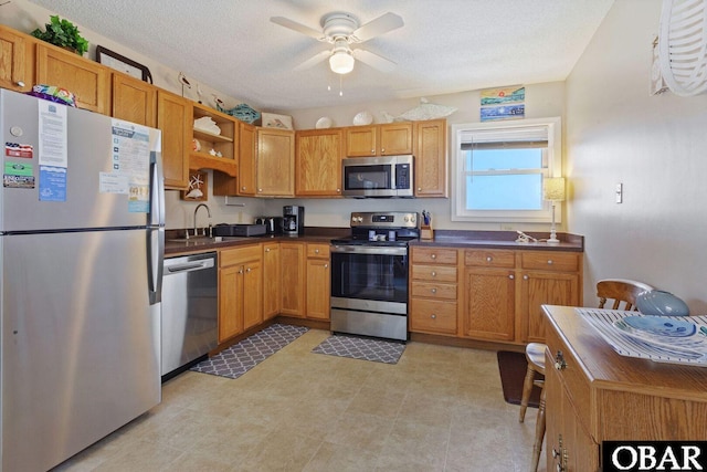 1401 N Virginia Dare Trl Unit # 5C, Kill Devil Hills, NC 27948 - kitchen featuring appliances with stainless steel finishes, dark countertops, ceiling fan, open shelves, and a sink