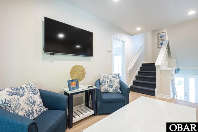 living area featuring light wood-type flooring, stairway, and recessed lighting