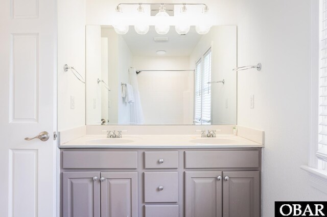 full bathroom featuring double vanity and a sink