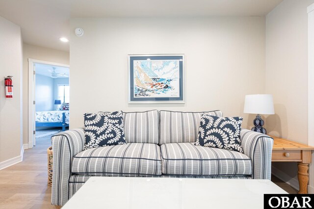 living room featuring light wood finished floors, recessed lighting, and baseboards