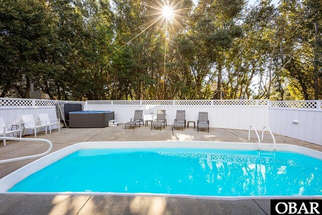 view of pool with a patio, a fenced backyard, a fenced in pool, and a hot tub