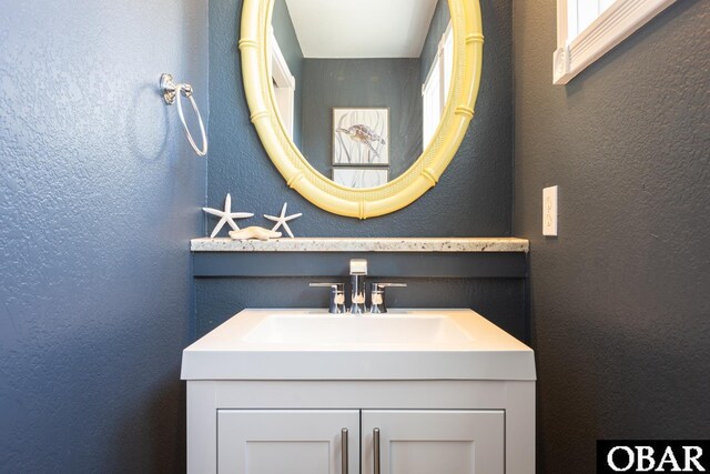 bathroom featuring a textured wall and vanity