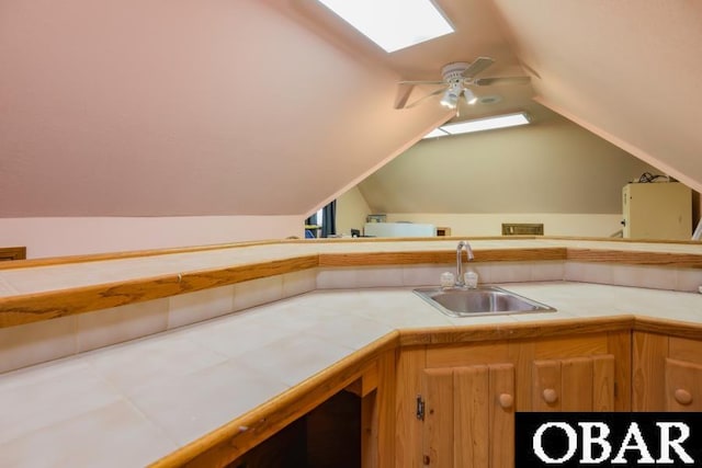 128 Daphne Ln Lot 17, Manteo, NC 27954 - kitchen featuring tile countertops, vaulted ceiling, a skylight, and a ceiling fan