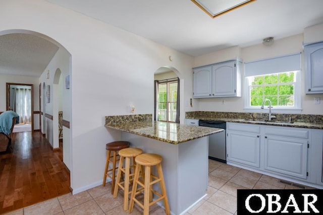 128 Daphne Ln Lot 17, Manteo, NC 27954 - kitchen with stainless steel dishwasher, dark stone countertops, a kitchen breakfast bar, and healthy amount of natural light